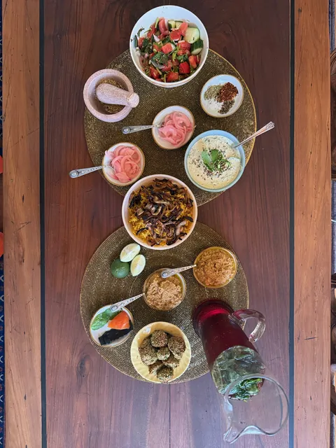 Overhead photograph of a Jordanian matchday meal on a long wooden table.
