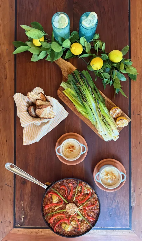 Overhead photograph of a Spanish matchday spread with asparagus, lemons and a skillet.