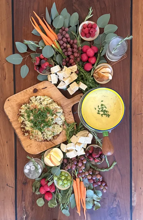 Overhead photograph of a Swiss matchday spread with soup, vegetables and cheese.
