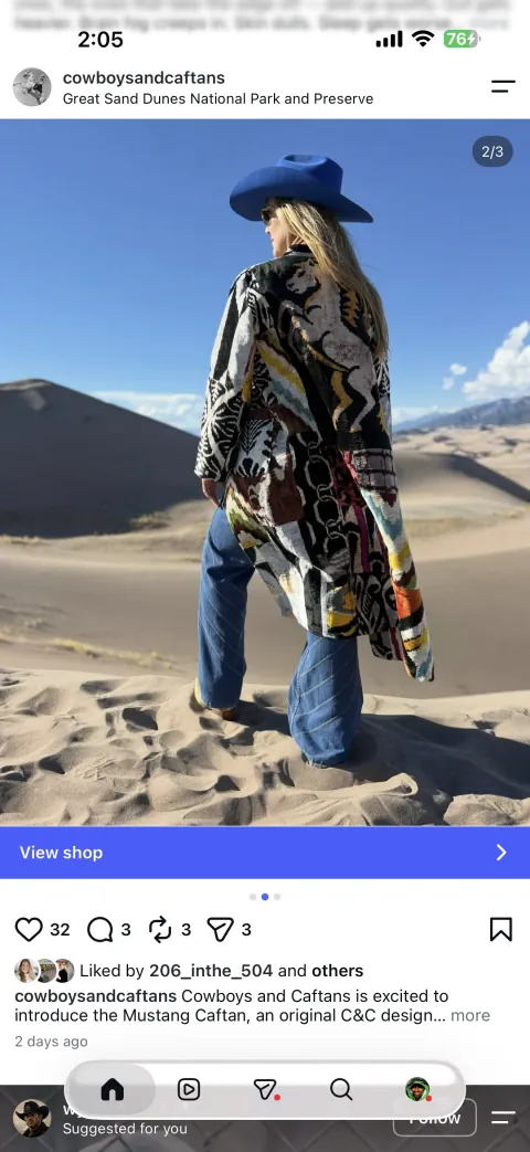 The second published Instagram frame of the same post: the Mustang caftan walking across the dune, seen from behind.